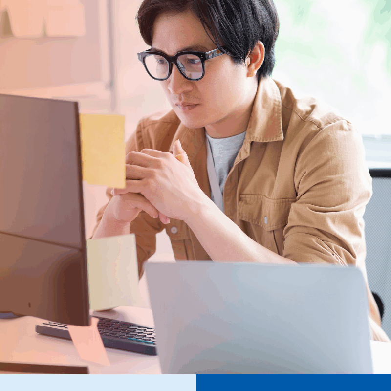 Bookkeeper in the Philippines working at a computer in a modern office, reviewing financial data for an offshore client.