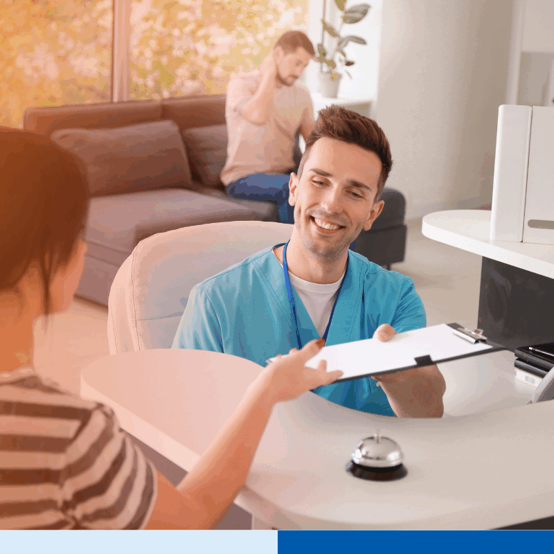 Front desk healthcare worker assisting patient with paperwork — highlights communication and workflow considerations in overcoming challenges in RCM offshoring.