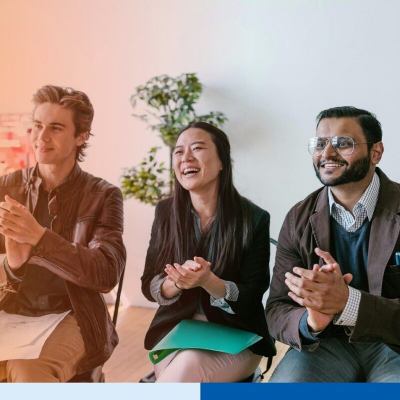 happy people clapping in corporate attire in office meeting