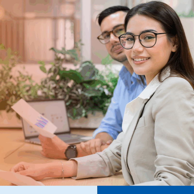 Two young professionals smiling while working.