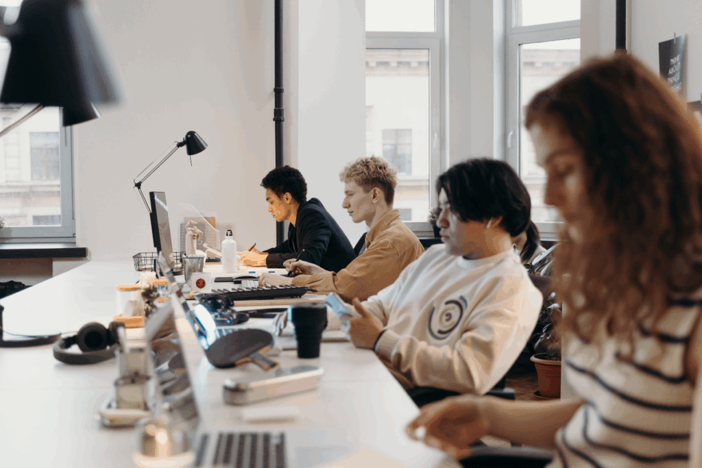 A diverse team of professionals working at computers in a modern office setting—representing the collaborative and scalable nature of content moderation outsourcing