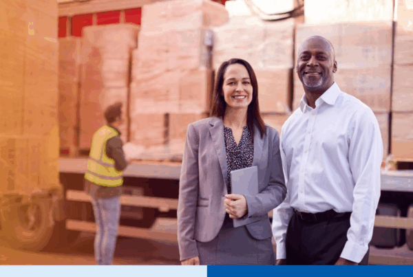 supply chain professionals smiling while holding a tablet