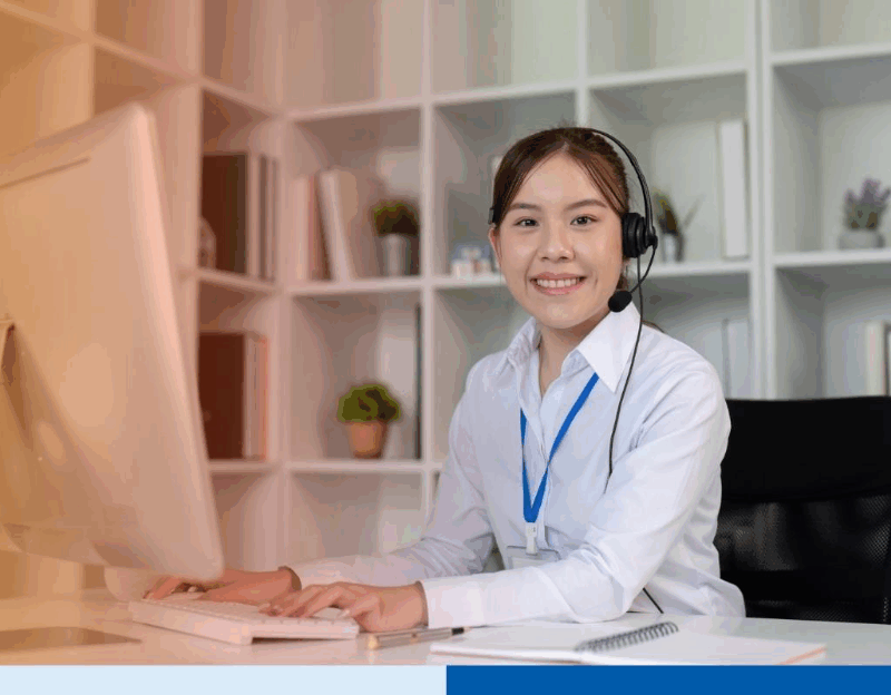asian woman smiling with desktop n professional corporate attire smiling with office background