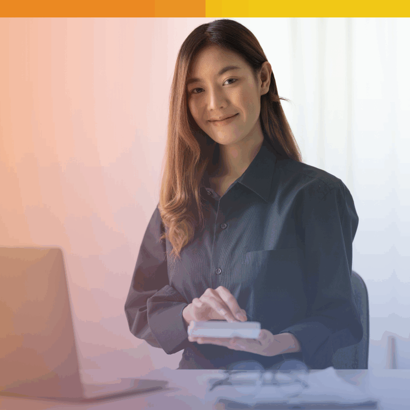 Smiling payroll professional using a calculator at her desk with a laptop, representing secure and efficient outsourced payroll support.