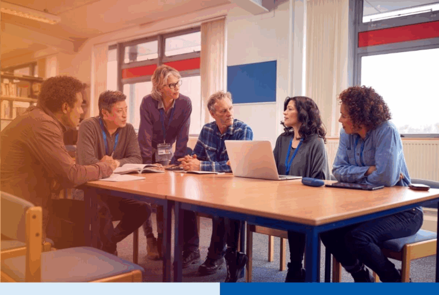 Diverse business team in a meeting discussing project strategy with a laptop in an office settingÂ