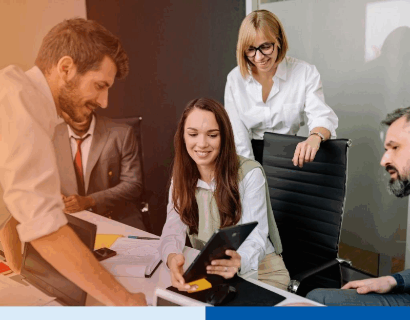 Group of business professionals discussing documents and digital devices in a modern office meeting, representing collaboration during the BPO switching process.
