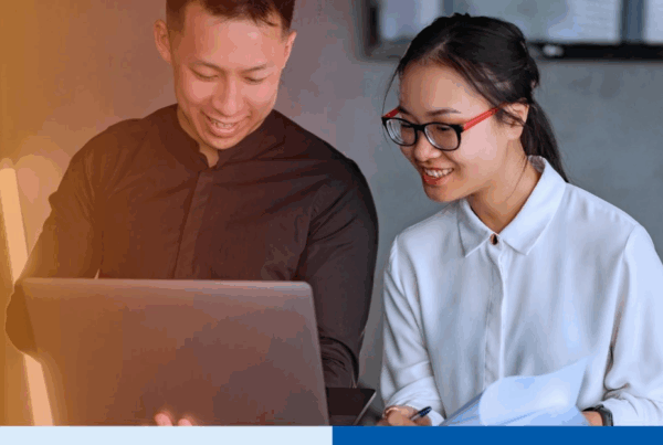 Two professionals collaborate on payroll outsourcing tasks using a laptop and documents in a modern office setting, illustrating teamwork and efficiency in the Philippines payroll outsourcing industry for U.S. firms in 2026.