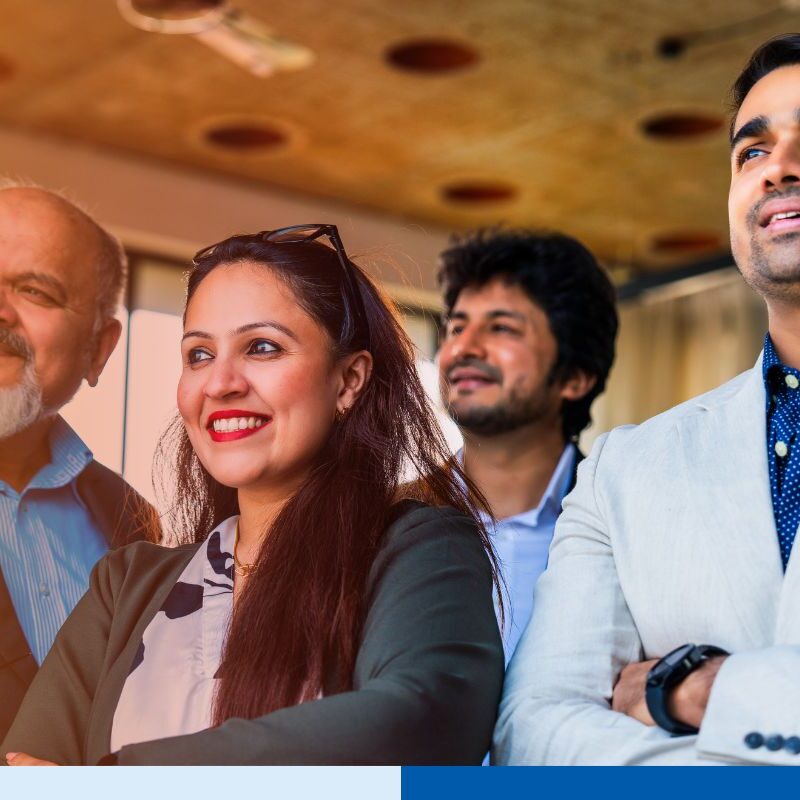 Corporate professionals standing with folded arms, smiling confidently in an office